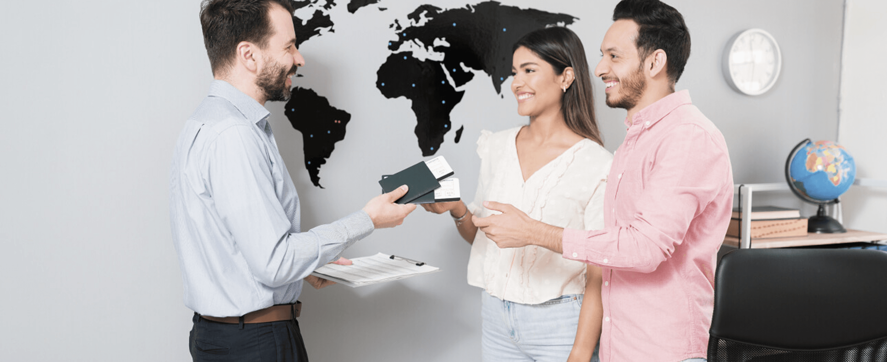 Immigration consultant handing passports to smiling clients